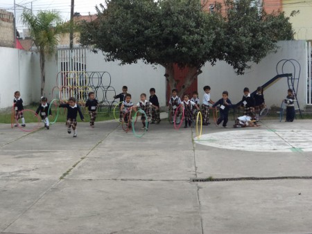 Educación física con aros, coordina, imprime fuerza y destreza.